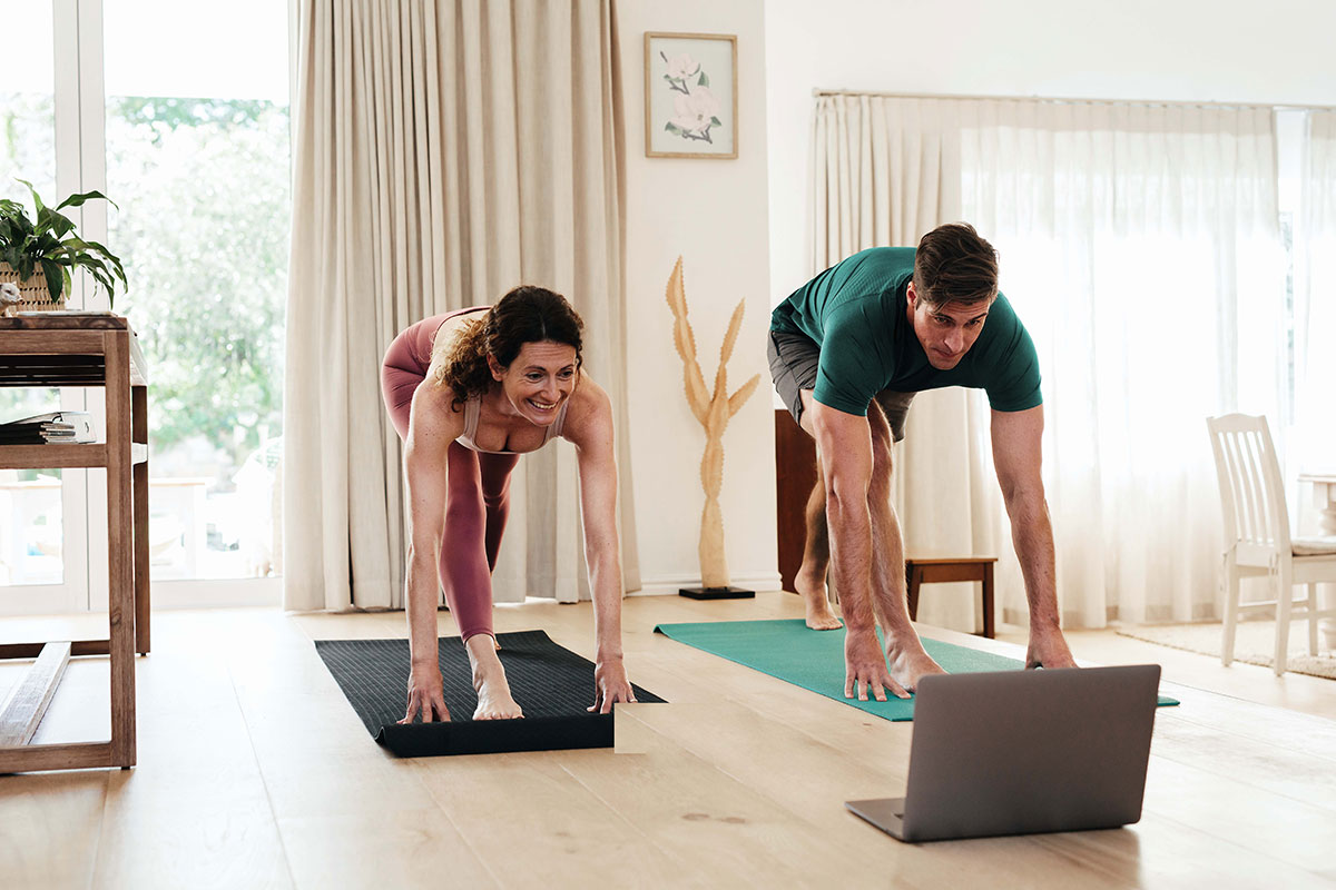 Couple exercising at home watching fitness video